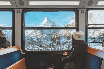 Blur foreground - young woman traveling looking out the window enjoying in Swiss Alps with the...