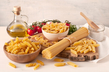 Verschiedene ungekochte Pasta mit Olivenöl, Tomaten und Salz