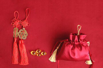 Chinese New Year, red silk pocket money bag, lucky golden coins with Chinese blessing words means...