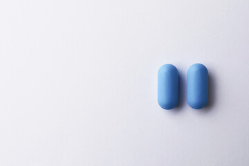 Pills and space for text on white background, top view. Potency problem