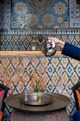 Moroccan serving mint tea in the traditional way