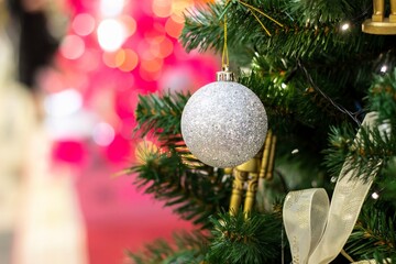 Christmas tree background and Christmas decorations in the mall. hine silver ball and ribbons on green fir. New Year theme