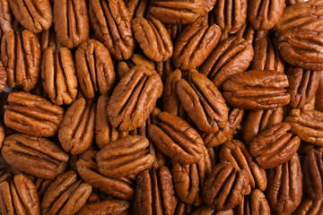 Tasty fresh ripe pecan nuts as background, top view