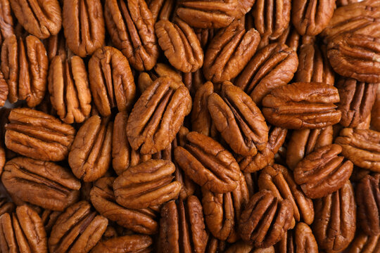 Tasty fresh ripe pecan nuts as background, top view