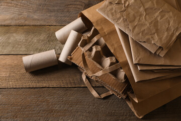 Different waste paper on wooden table, closeup. Space for text