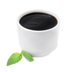 Balsamic glaze and basil leaves on white background