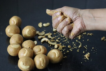 Preparation of moong dal laddu in a ball form with hand. It is a Protein rich, Indian sweet made of...