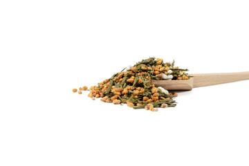 Green tea Japanese Genmaicha. Green tea mixed with roasted popped brown rice on wooden spoon isolated on white background.