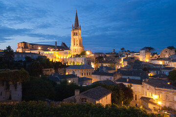 Overview of illuminated Saint Emilion village at dusk, famous for vineyards, in Bordeaux region, France