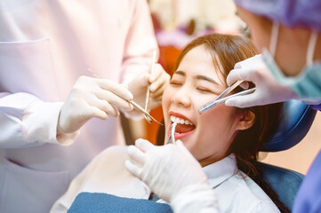 Dentist examining teeth patients in clinic for better dental health and a bright smile.Dentist is...