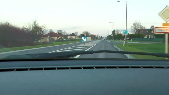 vue depuis une voiture d'une route nationale avec une entr&eacute;e dans une petite agglom&eacute;ration