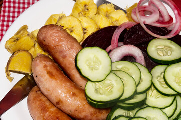 meal consisting of roasted sausage and various vegetables