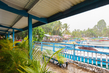 BIAK, WEST PAPUA, INDONESIA - August 2010: colorful veranda lounge of cheap but comfortable backpacker guesthouse, with heavy rain outside