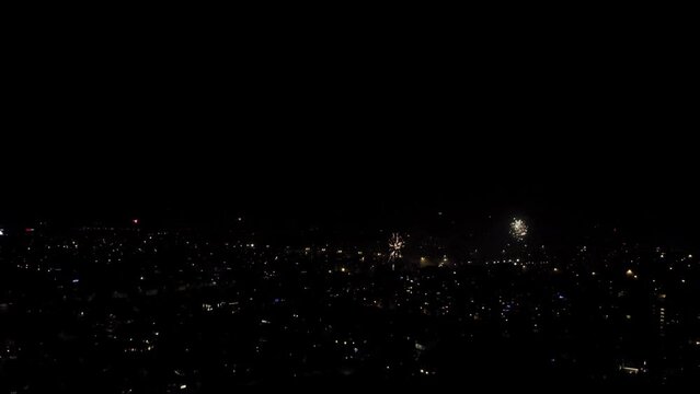 The night city celebrates the new year. December 31, New Year's Eve, fireworks explode over the houses. High quality FullHD footage