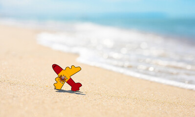 Fototapeta na wymiar Vacation on the coast of Spain. Airplane in the colors of the flag of Spain on the seashore