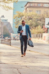 A senior businessman in a blue suit in an urban environment using a smartphone