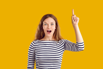 Got idea. Portrait of positive impressed young woman who understood something and has idea. Excited girl on orange background shows by her mimic and gestures that she has brilliant idea of something. - obrazy, fototapety, plakaty
