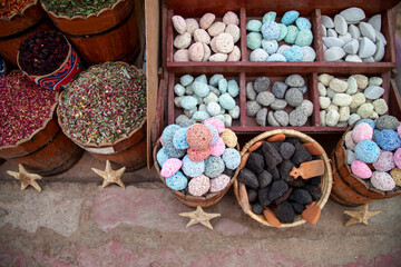 Colored natural pumice stones and dried flowers and leaves of various kinds of tea on street bazaar in Dahab, Egypt