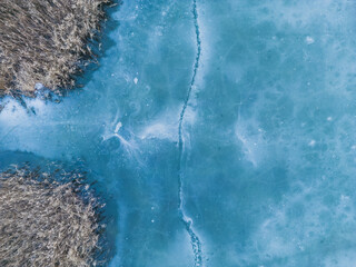 Aerial view of a frozen lake. Ice sheet background. Frozen waves on the lake. Ice background. Ice...