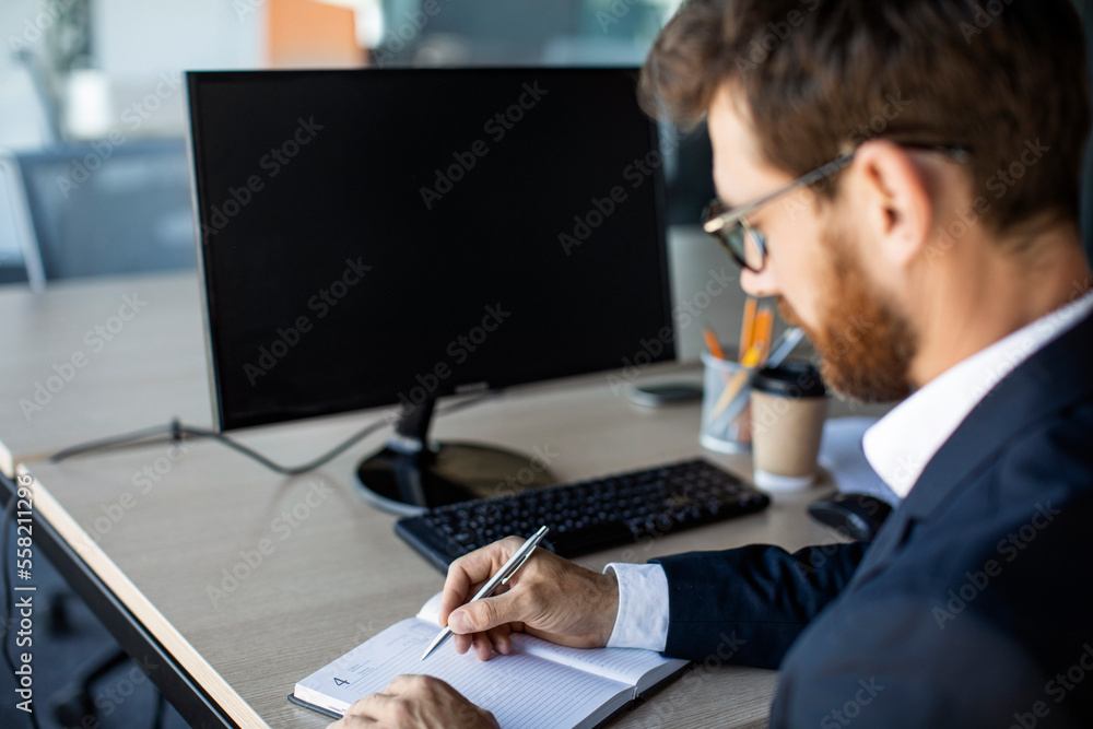 Aufkleber Online business class. Male office worker writing in notebook, taking notes and using computer with black screen, mockup