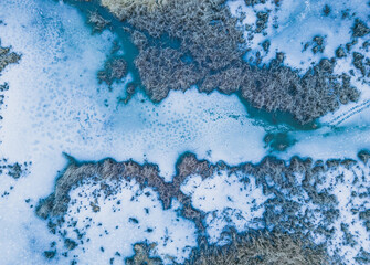 Aerial view of a frozen lake. Ice sheet background. Frozen grass on the lake. Ice background. Ice cover on a lake