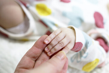 A mother holds a small child by the hand