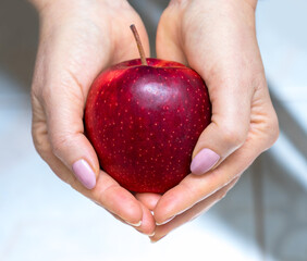 Girl holding a red apple.