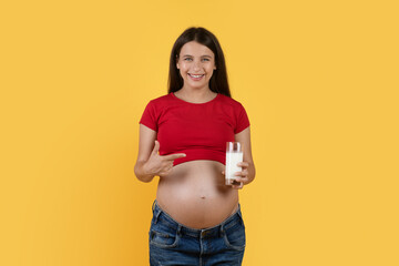 Beautiful Young Pregnant Woman Pointing At Glass Of Milk In Hand