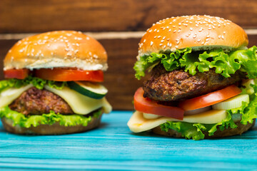 Delicious hamburgers on wooden table