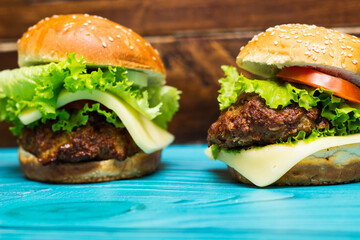 Delicious hamburgers on wooden table