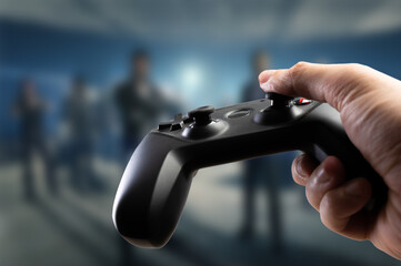Gamepad in the hand of a gamer on the background of a video game. Video games, online games, game strategy, youth culture. Close-up.