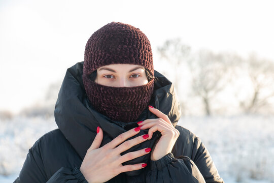 Beautiful girl in a brown balaclava. Fashionable hat on a beautiful woman. BALACLAVA GOOD PROTECTION FROM FROST AND WIND