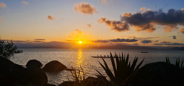 Por do Sol com canoagem na paisagem do mar calmo a c&eacute;u aberto