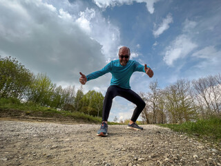Fototapeta na wymiar Happy running Sport man with blue shirt in free Spring nature 