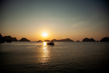 Bateau de pêche dans la mer au Vietnam au coucher du soleil