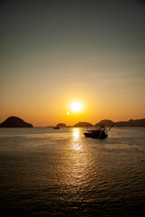 Naklejka na ściany i meble Bateau de pêche dans la mer au Vietnam au coucher du soleil