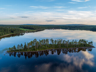Aerial View Small Island in the Sandsjön Lake in Sandsjönäs, Swedish Lappland during Sunset with reflections in the water