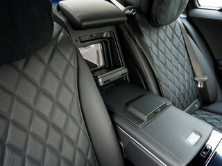 car refrigerator between the rear black leather seats of an expensive car