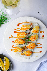 Baked mussels with cheese in shells on rice in a plate