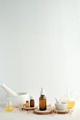 Skincare, aromatherapy, apothecary, spa, and beauty product with natural wooden plates and oil. White background, vertical, and copy space.