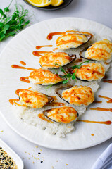 Baked mussels with cheese in shells on rice in a plate