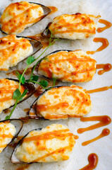 Baked mussels with cheese in shells on rice in a plate