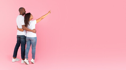 Cool offer. Unrecognizable african american spouses embracing and lady pointing at copy space, panorama