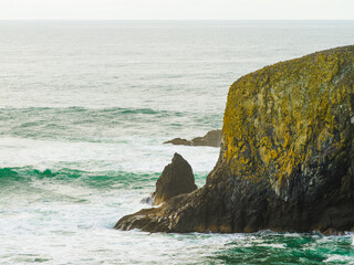 Big rock in the ocean. Turquoise water with white foamy waves, rock and stones in the ocean. Beautiful seascape. Tourism, travel, recreation, ecology, weather.