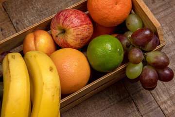 Crate with varied fruits, in warm tones, seen from above