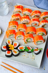Sushi rolls set with salmon and shrimp on light blue background, Flower Shaped Sushi Rolls, Japanese cuisine