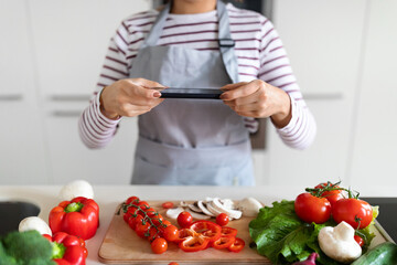Female hands taking photo of fresh organic vegetables