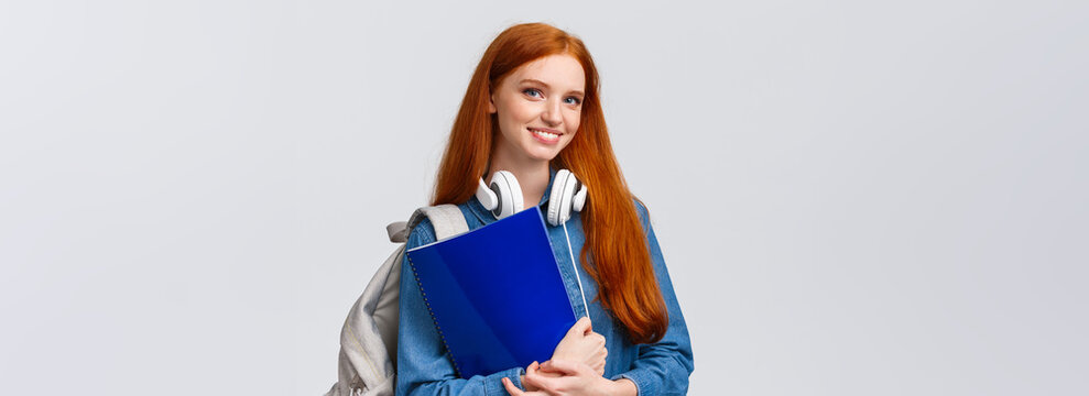 Charismatic Lovely Teenage College Girl, Redhead Female Student With Notebooks And Papers, Prepare Project For Todays Class, Wear Headphones Over Neck And Backpack, White Background