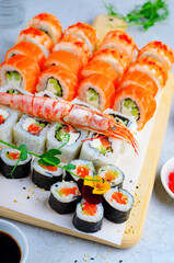 Sushi rolls set with salmon and shrimp on light blue background, Flower Shaped Sushi Rolls, Japanese cuisine