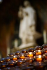 lighting candles in a Catholic Church to help light the path of our loved ones in the life beyond. 